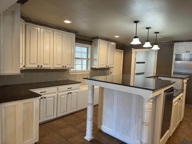 kitchen featuring built in refrigerator, white cabinets, pendant lighting, and a kitchen island