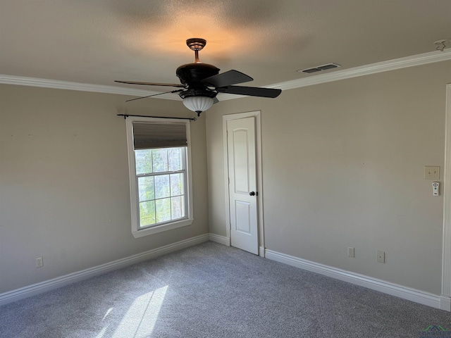 carpeted spare room featuring ceiling fan and ornamental molding