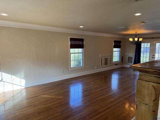 unfurnished living room with a wealth of natural light, crown molding, and a chandelier