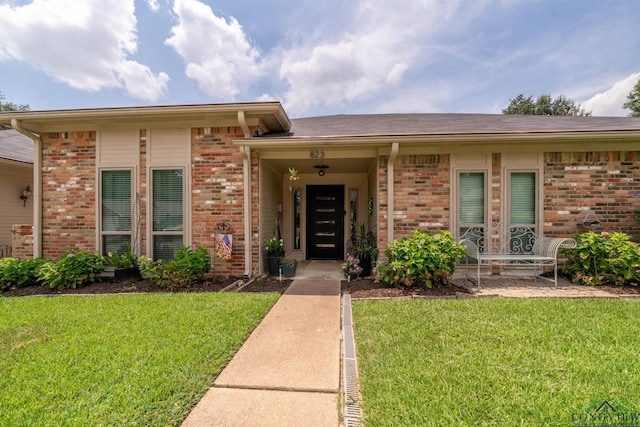 entrance to property with a lawn