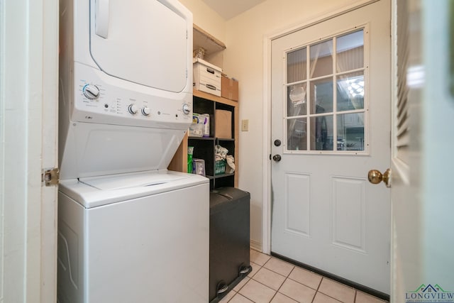 clothes washing area featuring light tile patterned floors and stacked washing maching and dryer