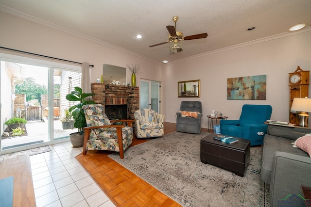 living room featuring a brick fireplace, ornamental molding, a textured ceiling, ceiling fan, and light tile patterned flooring