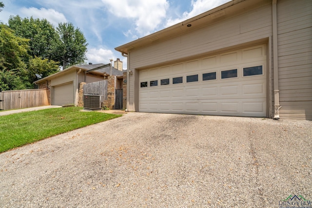 view of front of house with central AC, a front lawn, and a garage