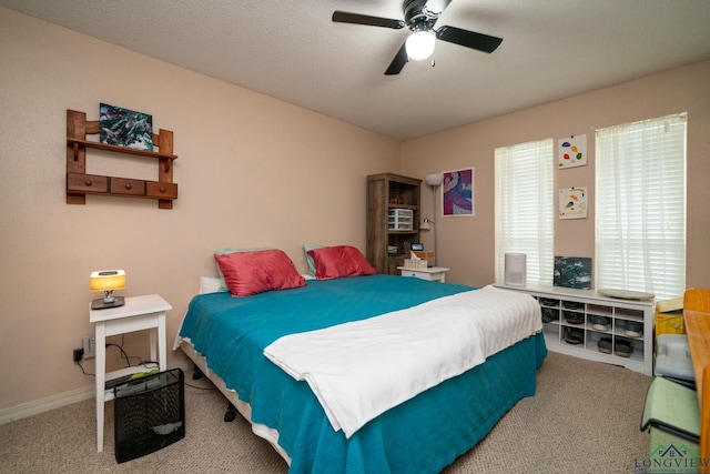 carpeted bedroom with ceiling fan and a textured ceiling