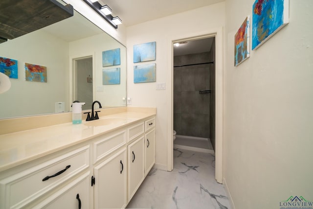 bathroom featuring vanity, toilet, and a tile shower