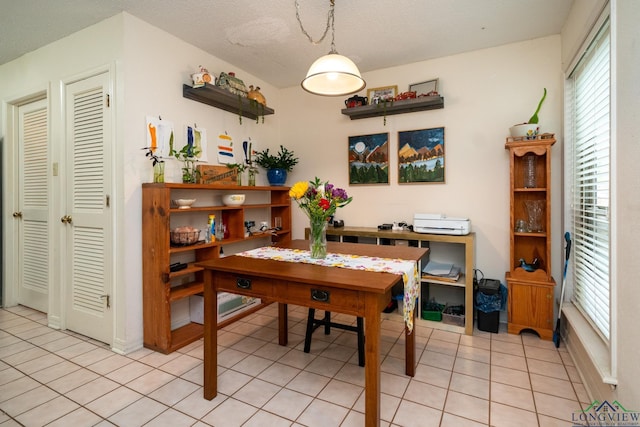 tiled dining space with a textured ceiling and plenty of natural light