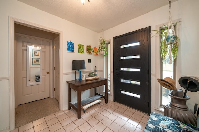 entrance foyer with light tile patterned floors and a textured ceiling