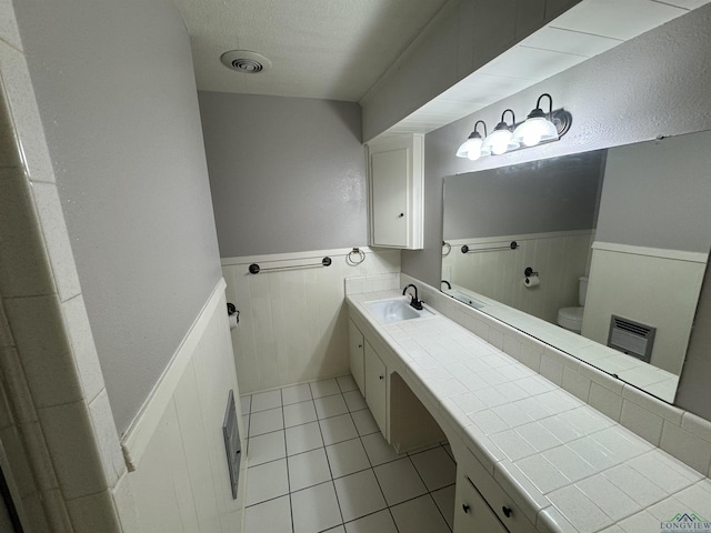 bathroom with tile patterned flooring, vanity, and toilet