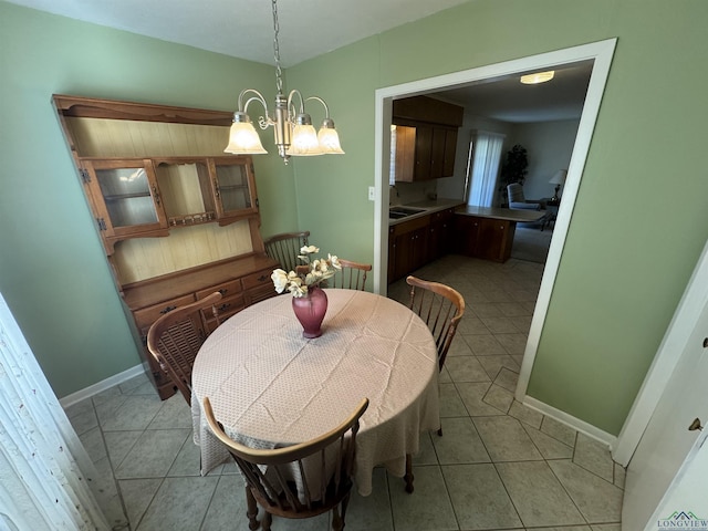 tiled dining room featuring a chandelier and sink