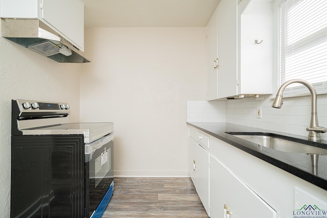 kitchen with backsplash, white cabinets, sink, range with electric cooktop, and light hardwood / wood-style floors