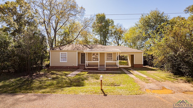 view of front of house featuring a porch, a front yard, and a carport