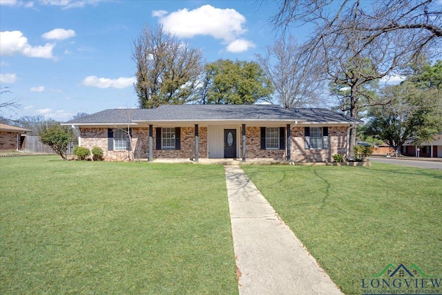 ranch-style home with covered porch, brick siding, and a front yard