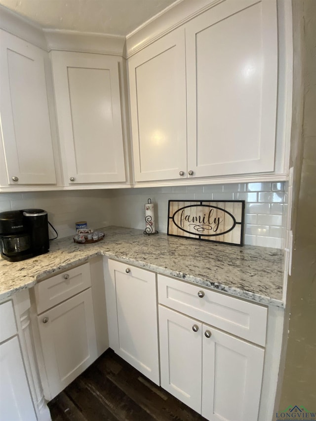 kitchen with dark wood-style floors, tasteful backsplash, white cabinetry, and light stone counters