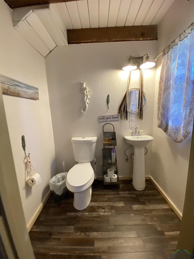 half bathroom with a sink, beamed ceiling, wood finished floors, and wood ceiling