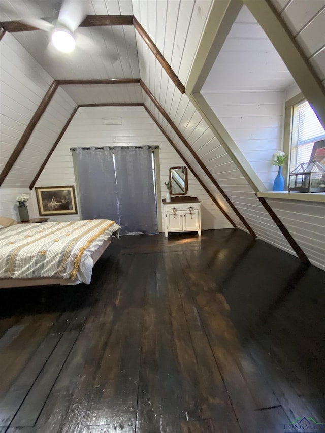 unfurnished bedroom with lofted ceiling, wood finished floors, and wooden walls