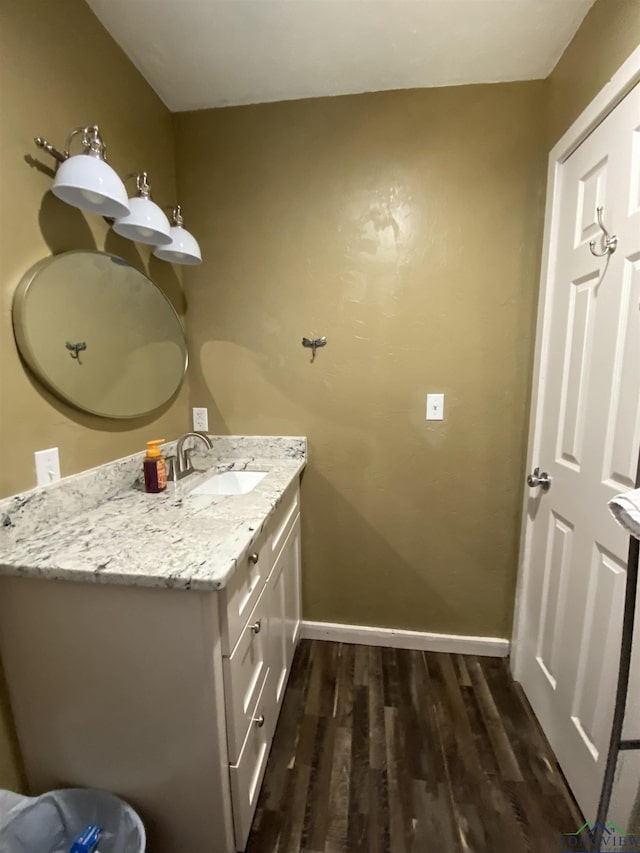 bathroom featuring baseboards, wood finished floors, and vanity