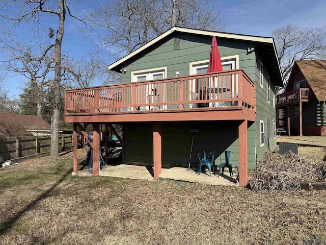 rear view of property featuring a deck, a patio, and fence