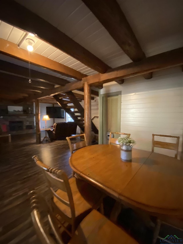 dining space featuring wood ceiling, wood finished floors, beam ceiling, and wooden walls