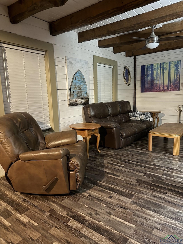 living area featuring dark wood-style floors, beamed ceiling, and wooden walls