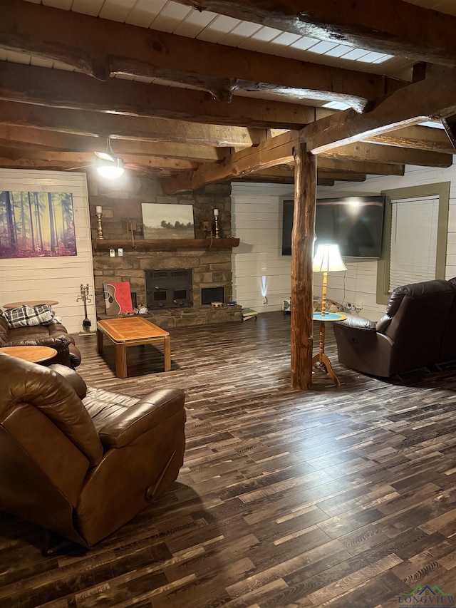 living room with dark wood-style floors, beamed ceiling, and a stone fireplace