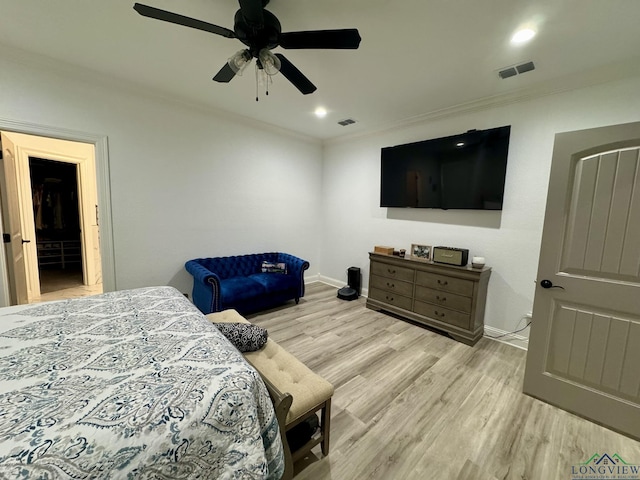 bedroom with visible vents, light wood-style floors, and crown molding