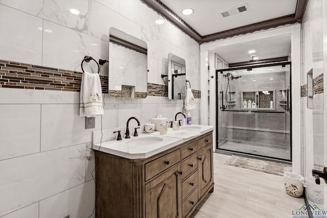 full bath featuring a sink, a stall shower, visible vents, and tile walls