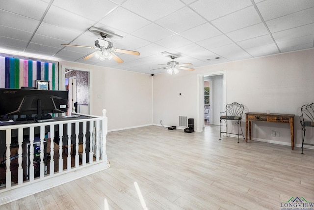 interior space with a drop ceiling, visible vents, baseboards, and wood finished floors