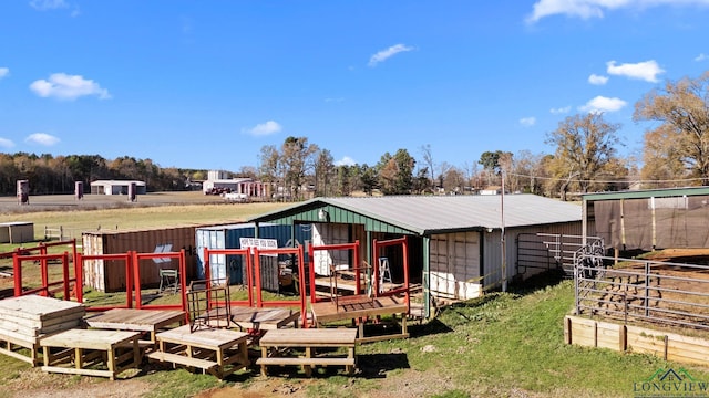 back of property featuring metal roof, an outbuilding, and an exterior structure