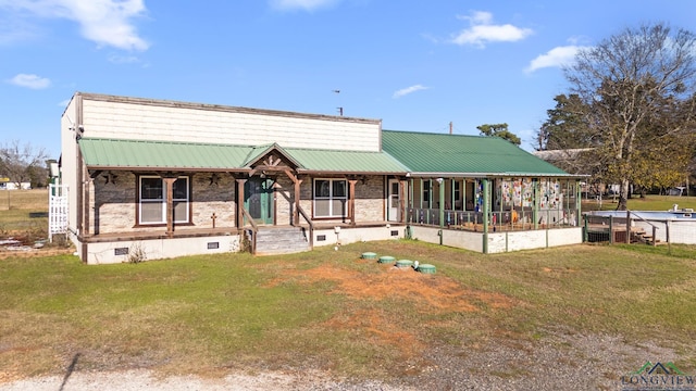 view of front of home featuring brick siding, a porch, crawl space, metal roof, and a front lawn