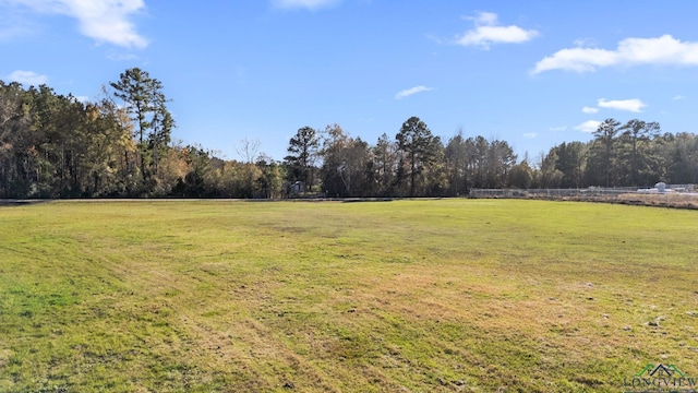 view of yard featuring a rural view and a view of trees