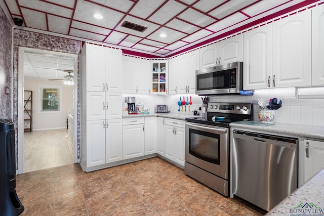 kitchen featuring stainless steel appliances, visible vents, decorative backsplash, and a ceiling fan