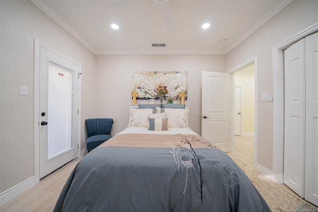 bedroom with light hardwood / wood-style floors, crown molding, and a closet