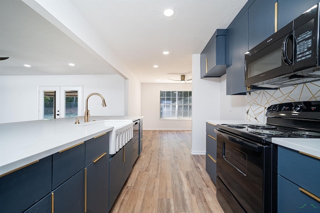 kitchen with french doors, light wood-type flooring, blue cabinets, sink, and black appliances