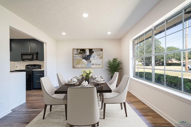 dining space featuring dark hardwood / wood-style flooring and a textured ceiling