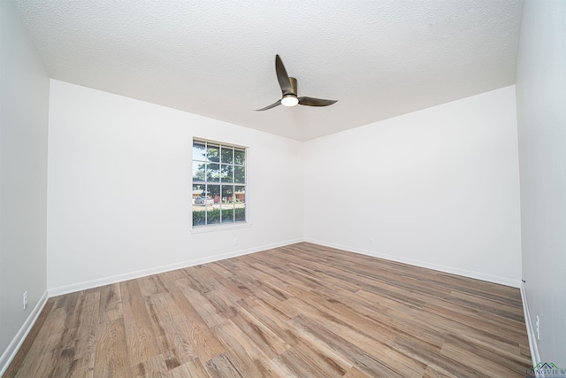 empty room with a textured ceiling, hardwood / wood-style flooring, and ceiling fan