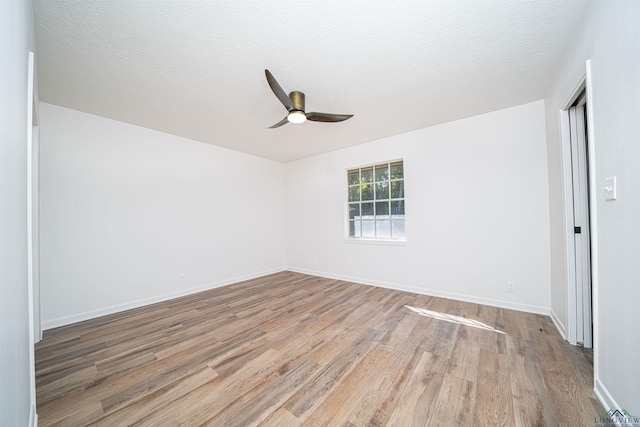 spare room featuring ceiling fan, wood-type flooring, and a textured ceiling