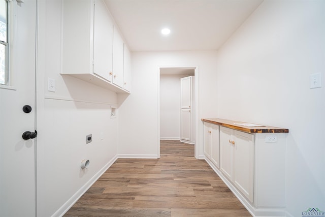 laundry room featuring cabinets, light wood-type flooring, washer hookup, and hookup for an electric dryer