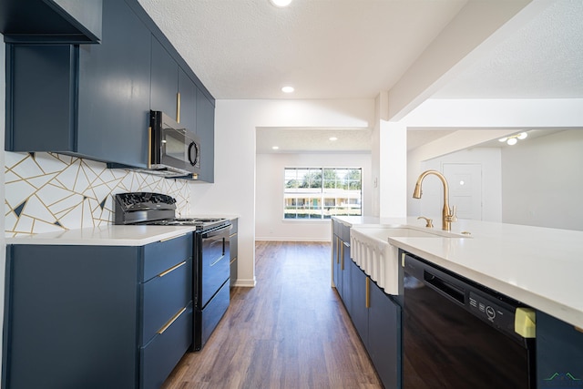 kitchen featuring sink, blue cabinets, dark wood-type flooring, and black appliances