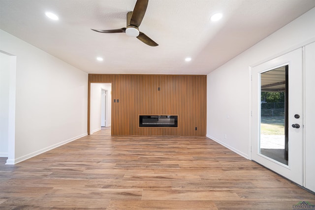 unfurnished living room with a fireplace, light hardwood / wood-style floors, and ceiling fan