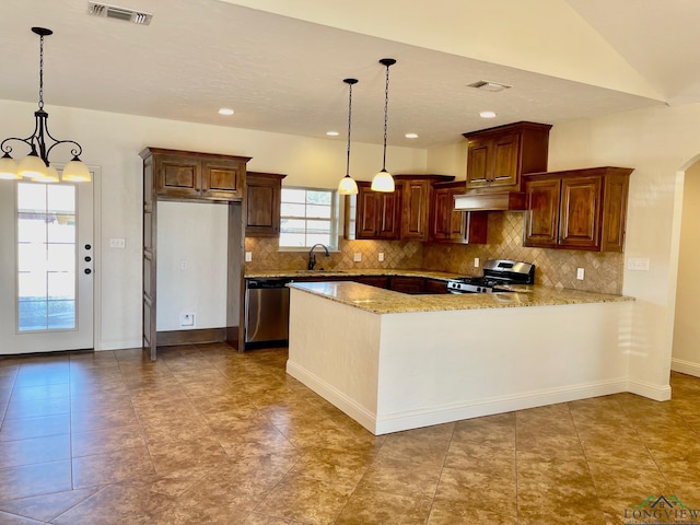 kitchen with sink, decorative light fixtures, vaulted ceiling, kitchen peninsula, and appliances with stainless steel finishes