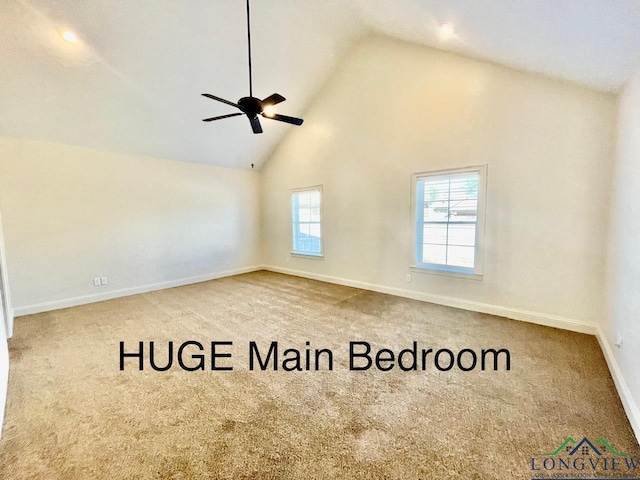 carpeted empty room with high vaulted ceiling and ceiling fan