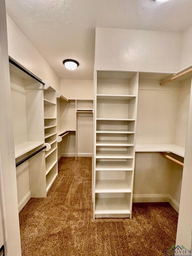 spacious closet with dark carpet