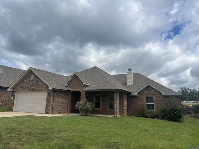 view of front of property with a front yard and a garage