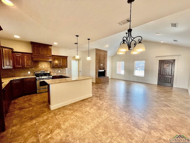 kitchen featuring stainless steel range with gas cooktop, vaulted ceiling, tasteful backsplash, hanging light fixtures, and a chandelier