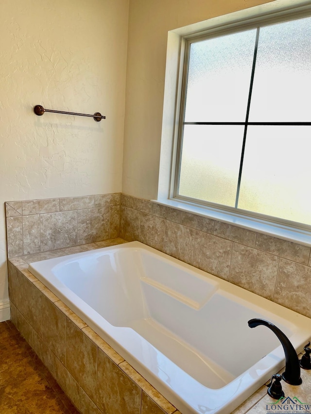 bathroom with tiled bath, tile patterned floors, and a wealth of natural light