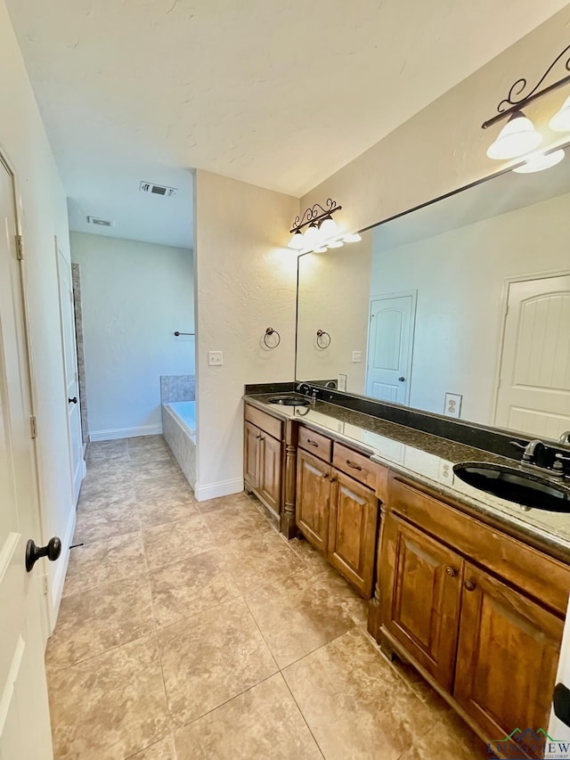 bathroom with tiled tub and vanity