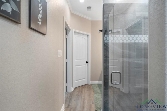 204 Nolan Farms, Winona, TX 75792 - bathroom featuring hardwood / wood-style flooring, crown molding, and a shower with door