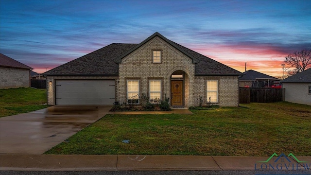 french provincial home featuring a yard and a garage