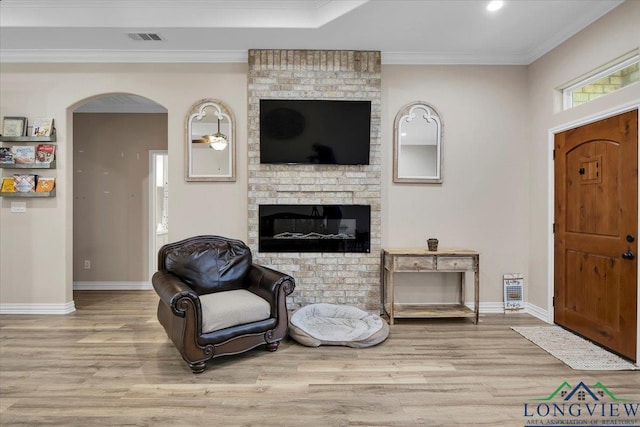 204 Nolan Farms, Winona, TX 75792 - foyer featuring ornamental molding, a brick fireplace, and light hardwood / wood-style flooring
