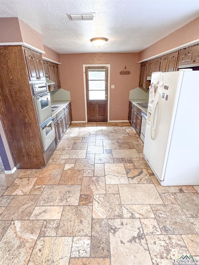 300 Delwood Dr, Longview, TX 75605 - kitchen with light countertops, stone tile floors, white appliances, baseboards, and visible vents